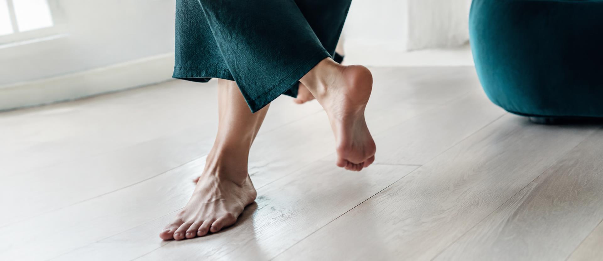 Piedi nudi che si muovono su un pavimento di legno chiaro